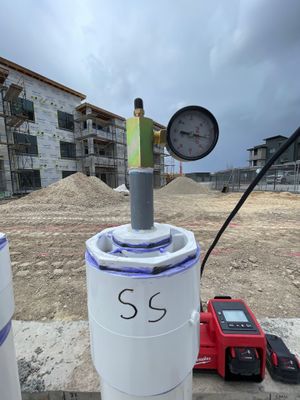 Test gauge and hand pump — we fill the pipe with air and watch the needle for days